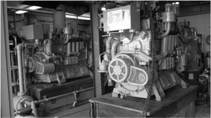 Black and white photo of room with engines