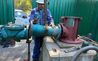 Worker with his hands on a pipe to a well