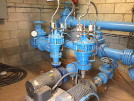 Blue pumping equipment inside a masonry building