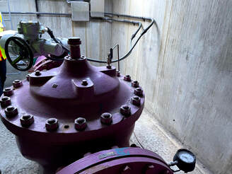 Large purple valve surrounded by concrete building